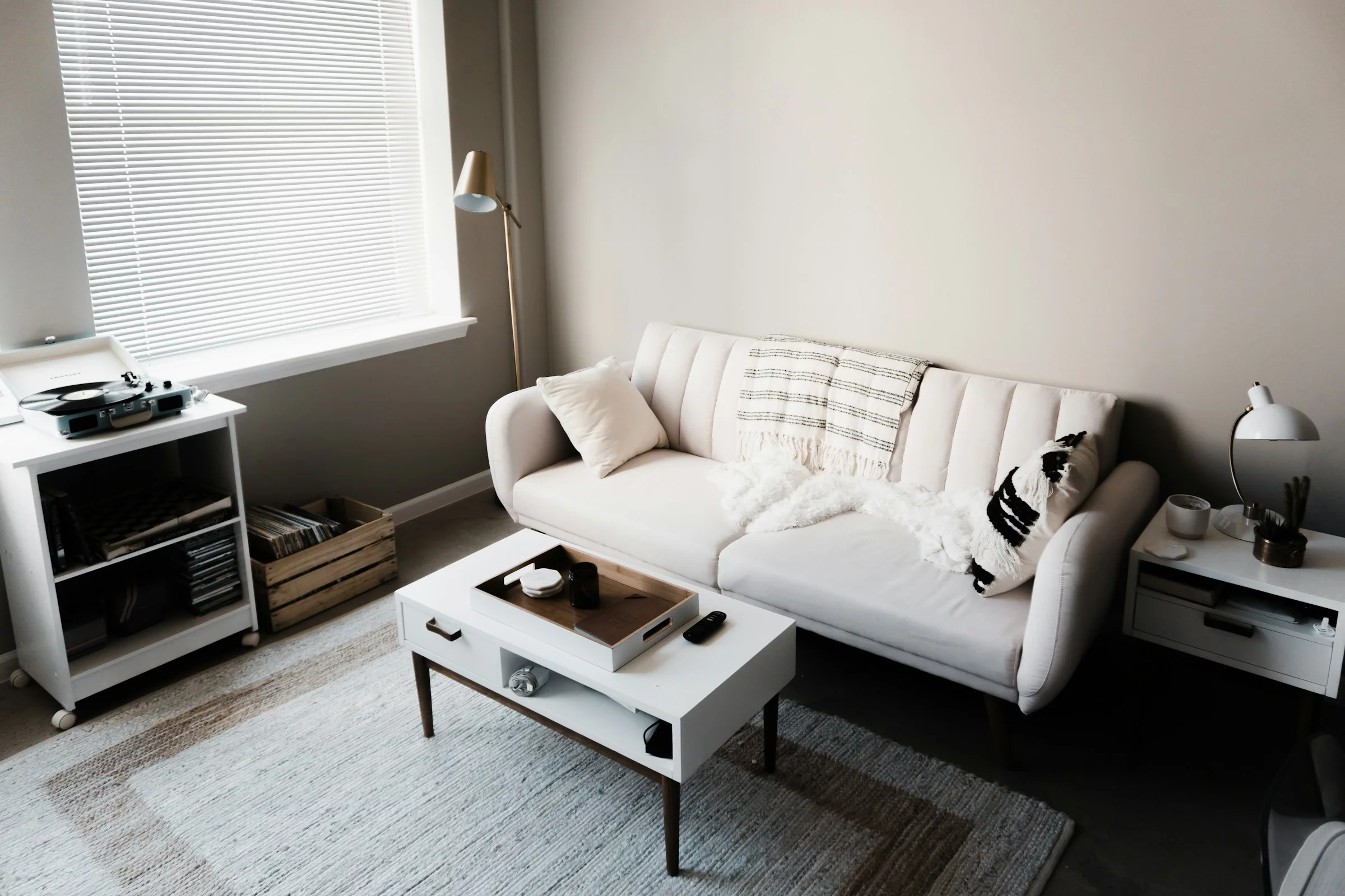 Wohnzimmer mit einem weissen Sofa, Couchtisch und Plattenspieler