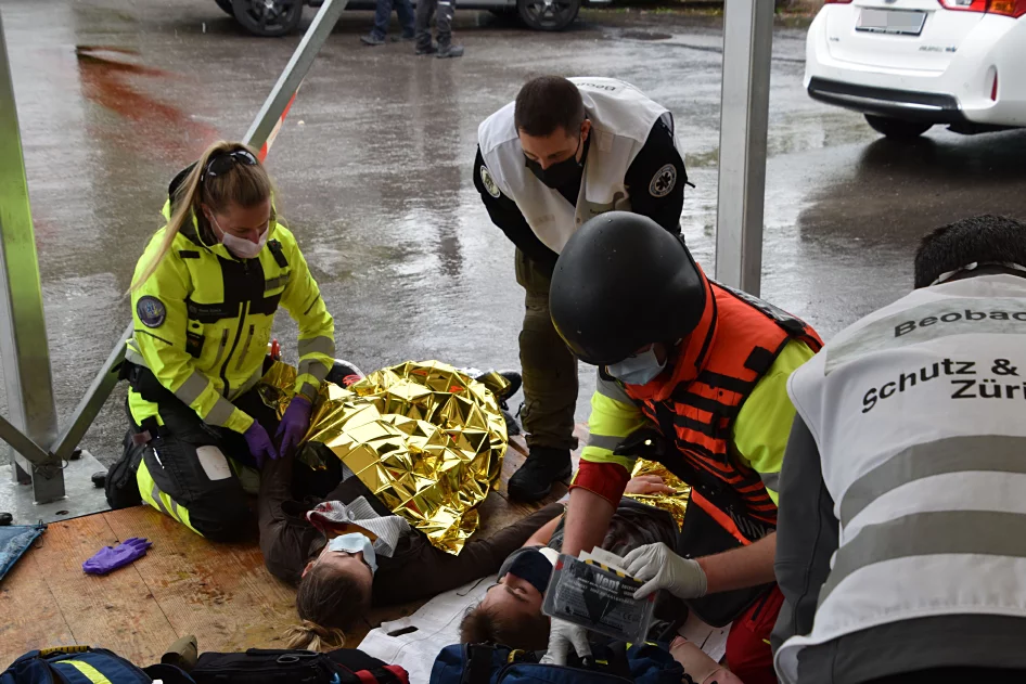 Einsatzkräfte triagieren verletzte Personen.