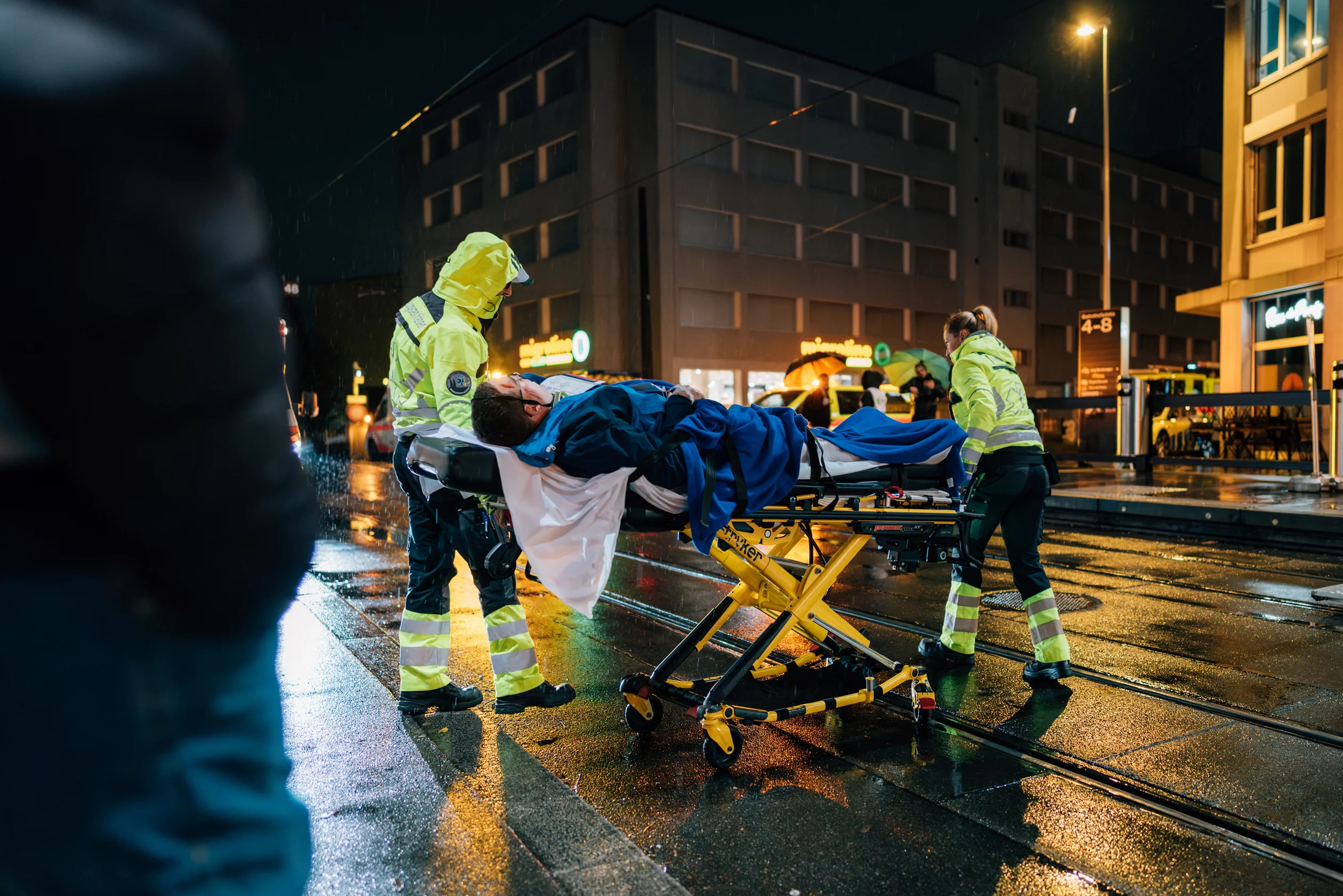 Zwei Rettungssanitäter transportieren eine verletzte Person auf einer Trage