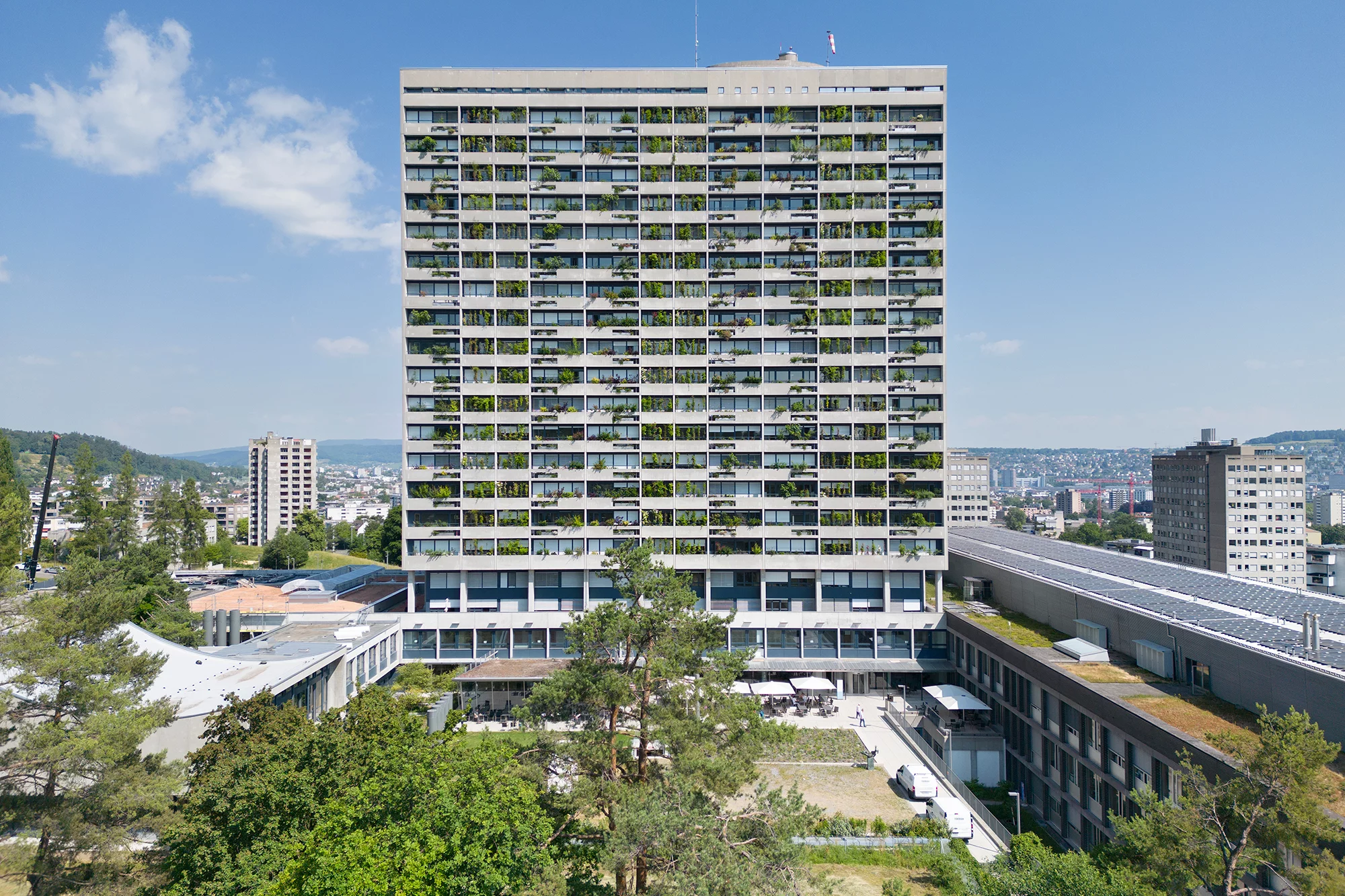 Das Foto wirft einen Blick auf den instandgesetzten Turm mit begrünter Fassade mit dem Bettenhaus im Hintergrund.