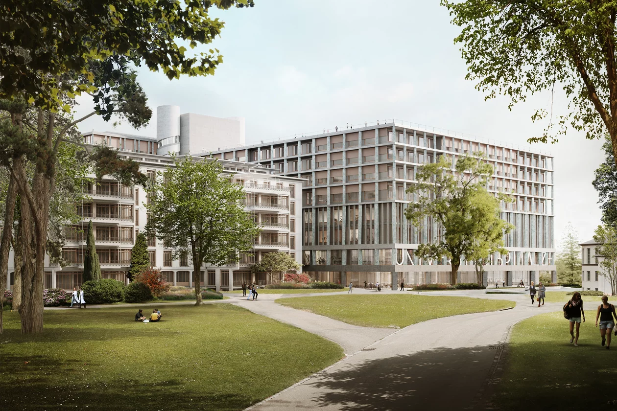 Zwei moderne, helle, mehrgeschossige Gebäude grenzen an einen Park mit Rasen und Bäumen