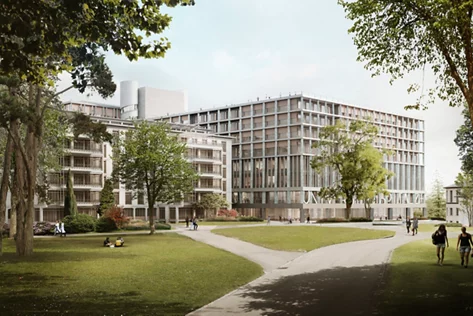Zwei moderne, helle, mehrgeschossige Gebäude grenzen an einen Park mit Rasen und Bäumen