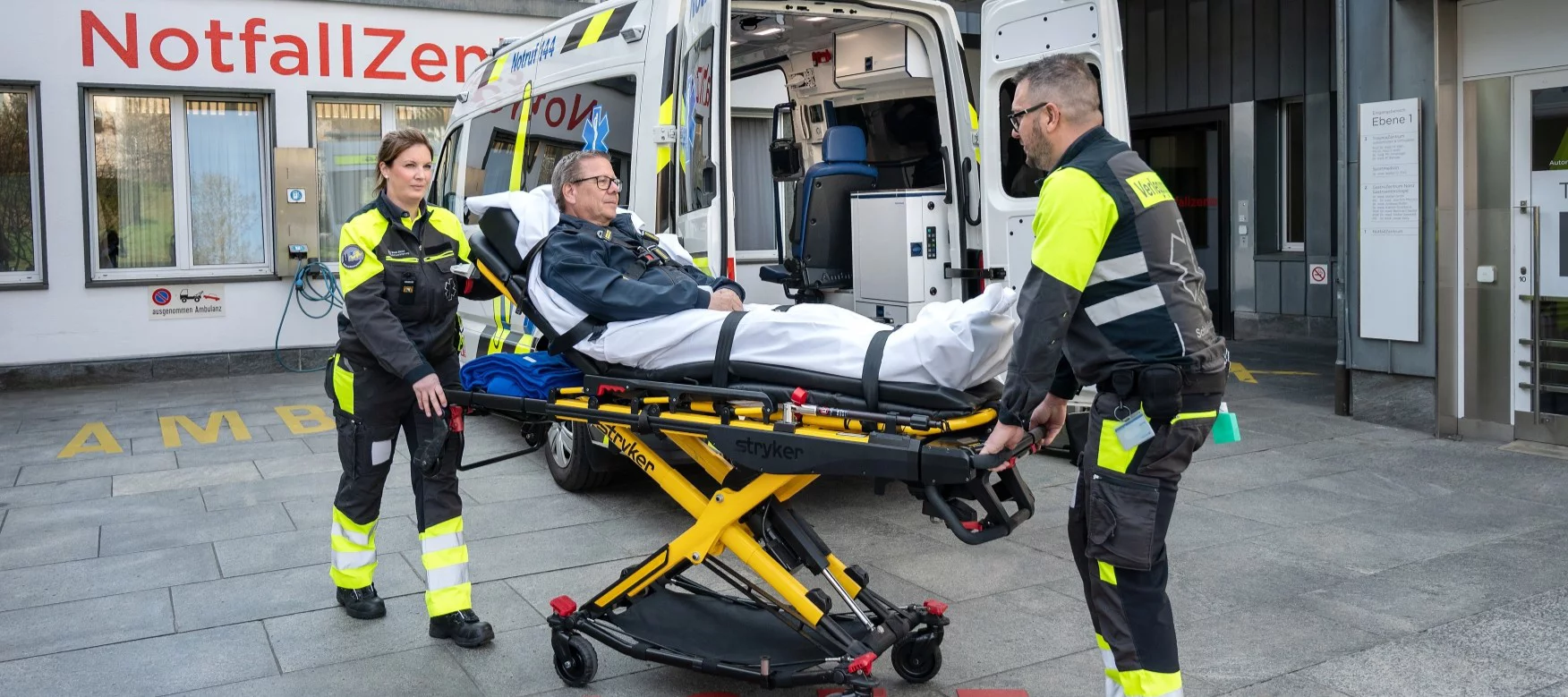 Transportsanitäter*innen und Patient bei einer Verlegung.