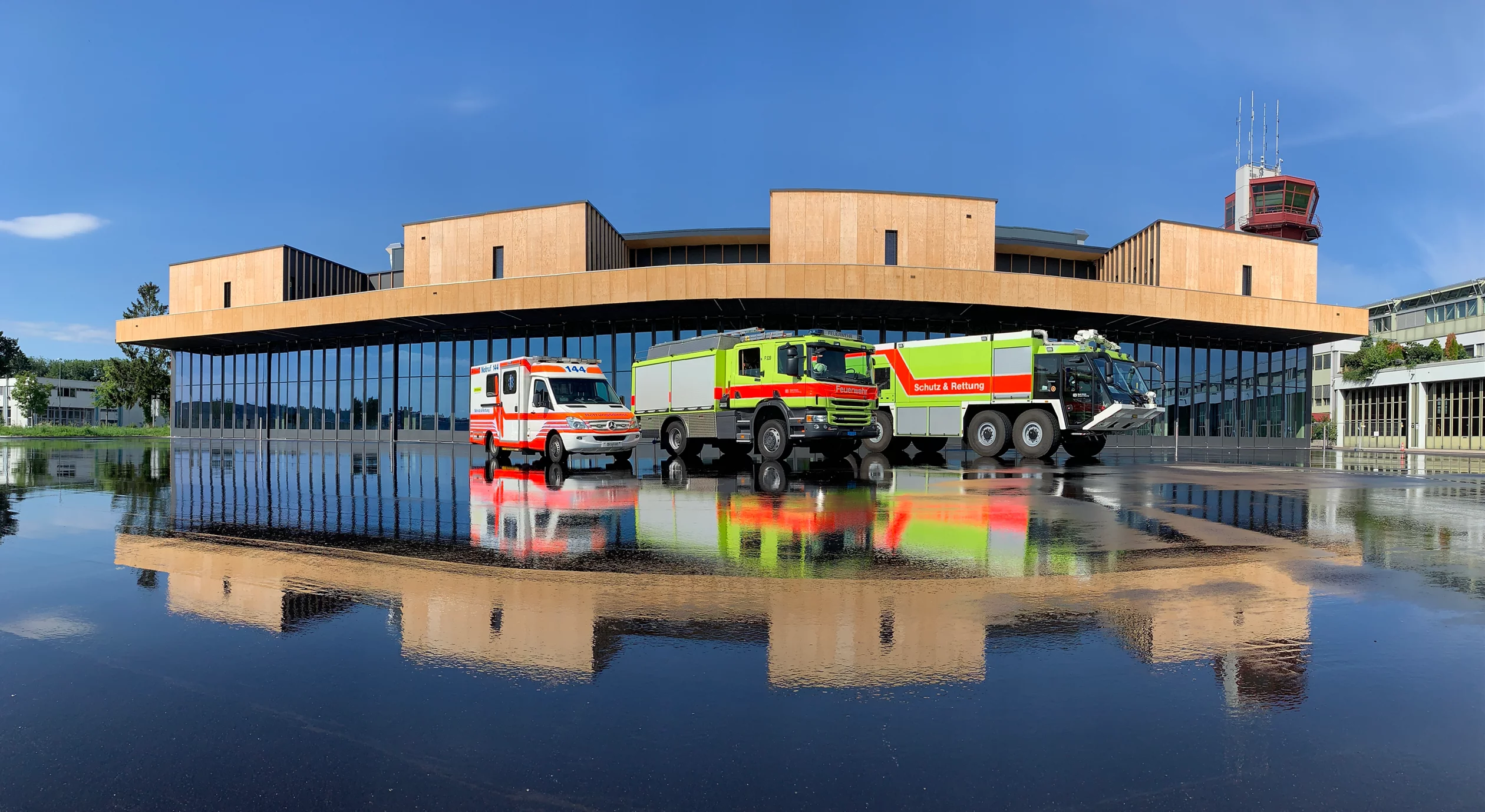 Das Foto wirft einen Blick auf die Wache des Flughafen Zürich mit drei Einsatzfahrzeugen im Vordergrund.