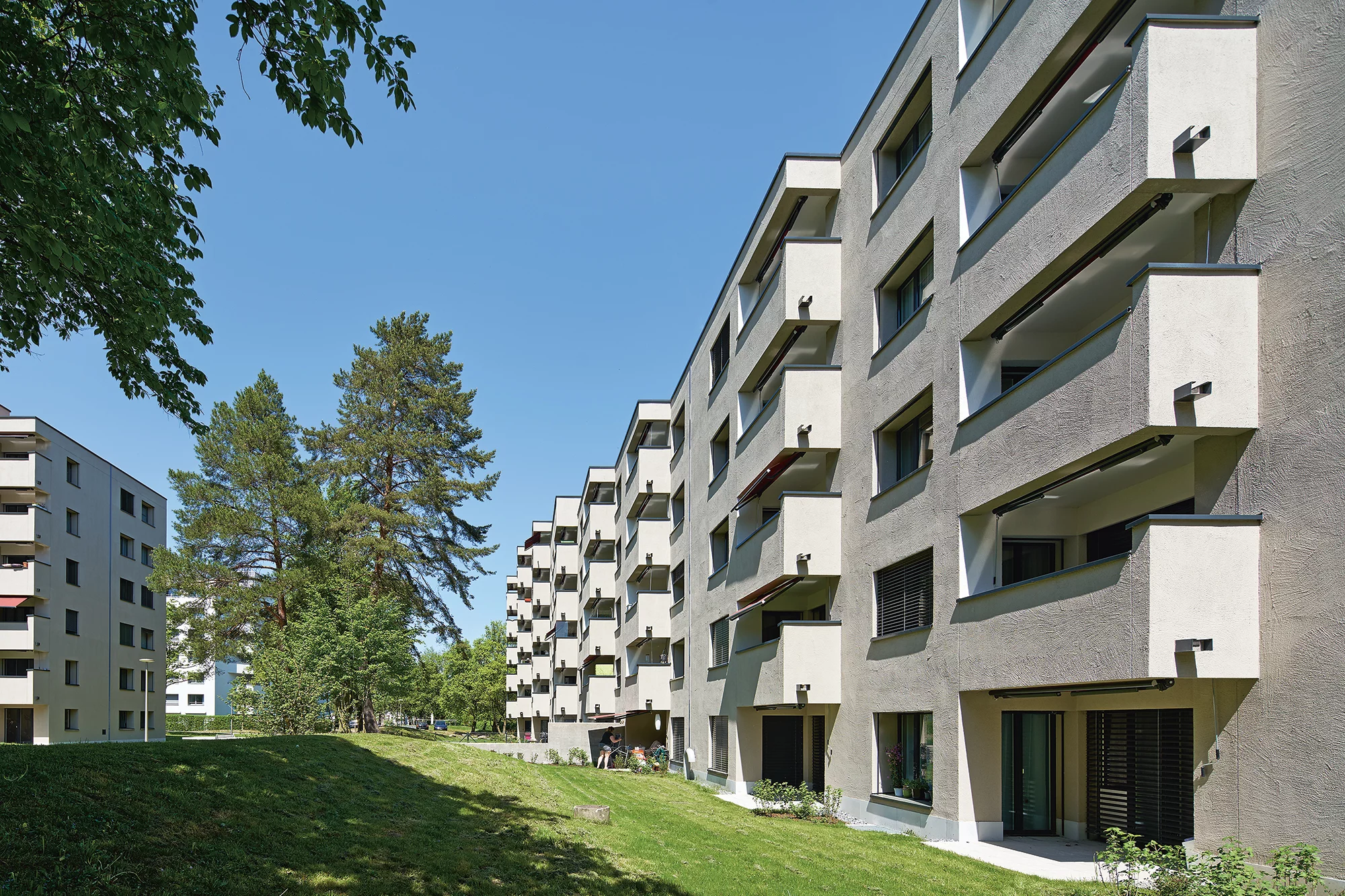 Ein mehrstöckiges Gebäude, das durch seine vielen Fenster und Balkone auffällt.