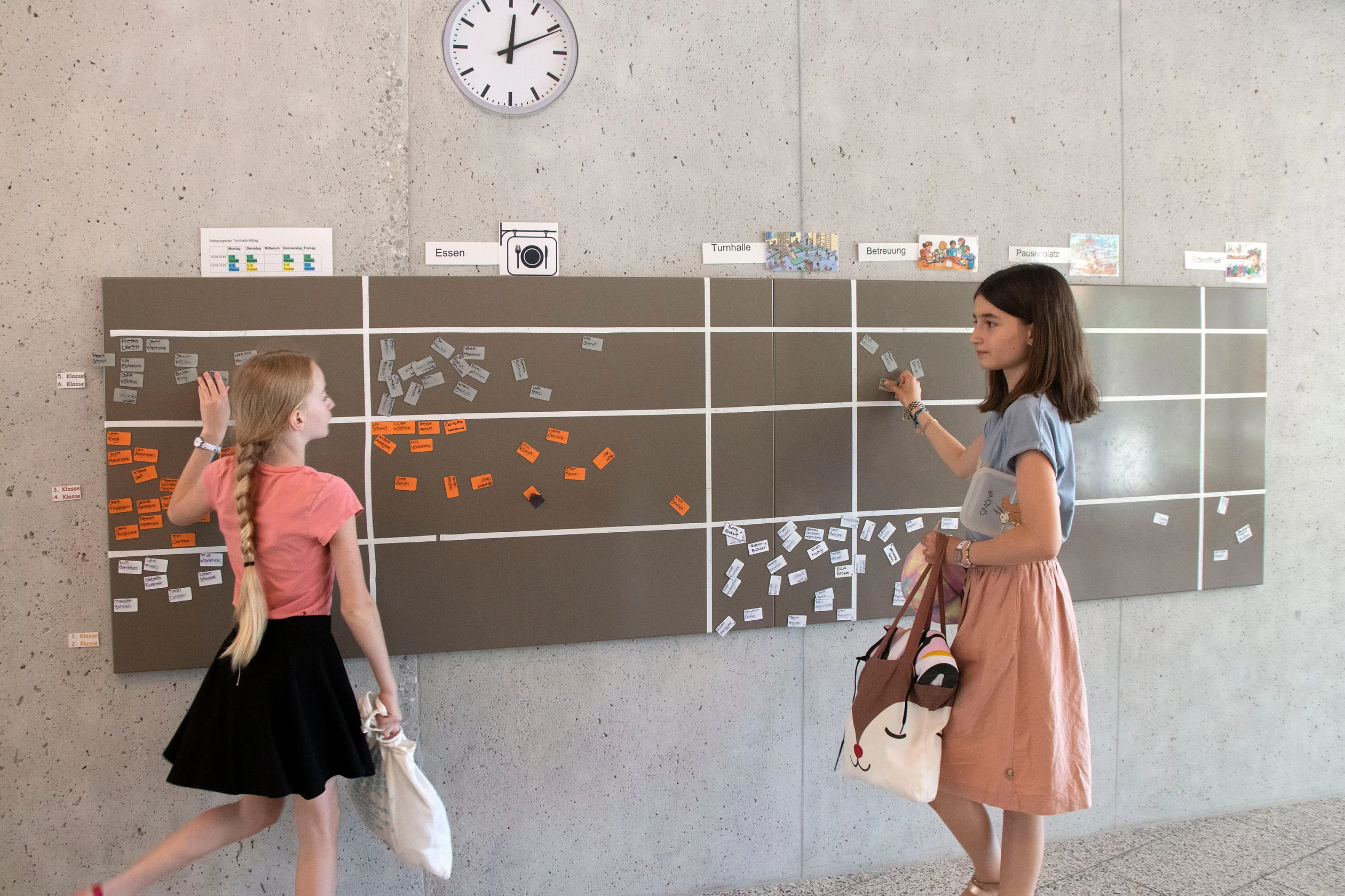 Zwei Schüler*innen stehen an einer Planwand