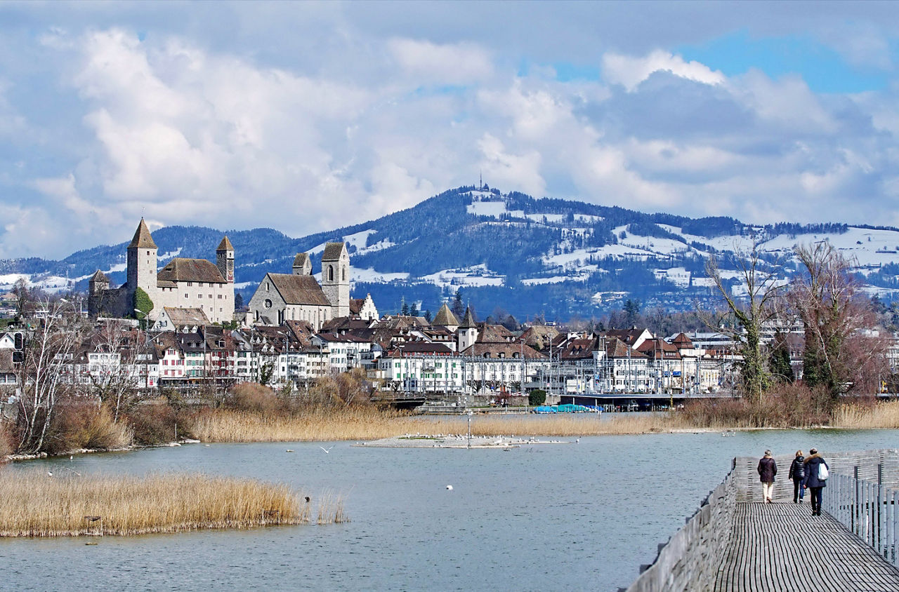 Rapperswil im Zürichsee mit dem verschneiten Bachtel im Hintergrund.