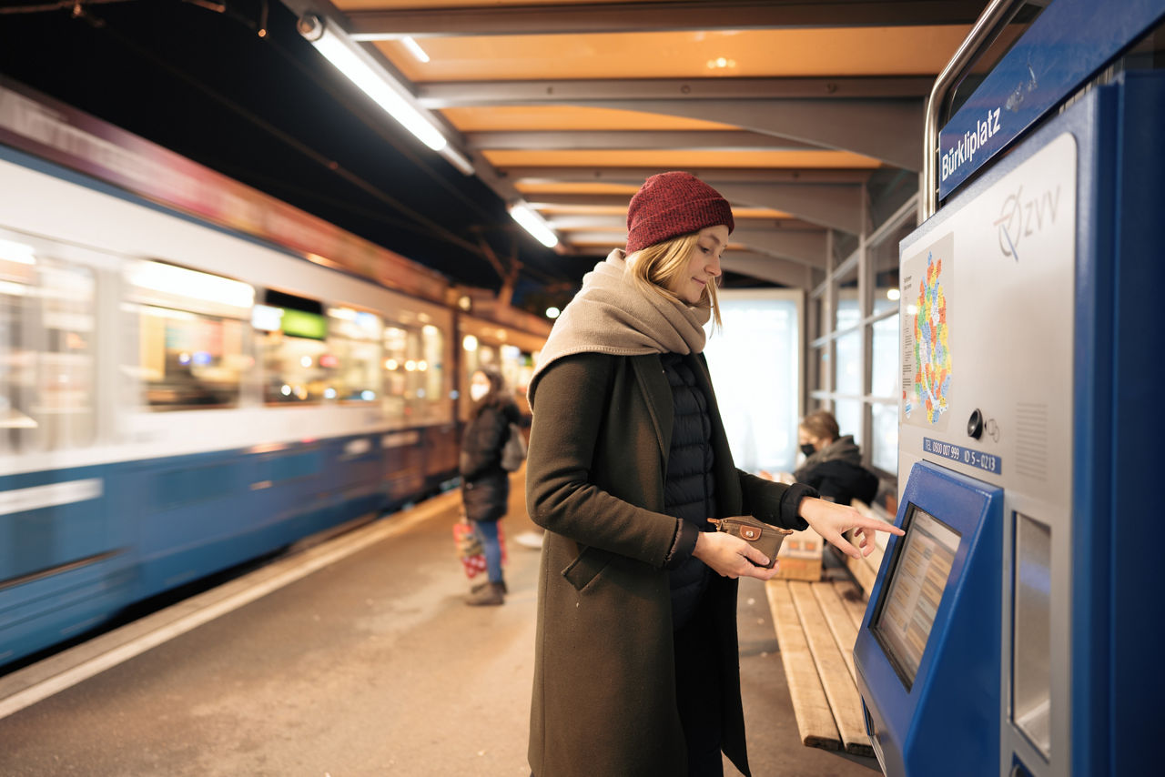 Frau am Ticketautomaten im Winter