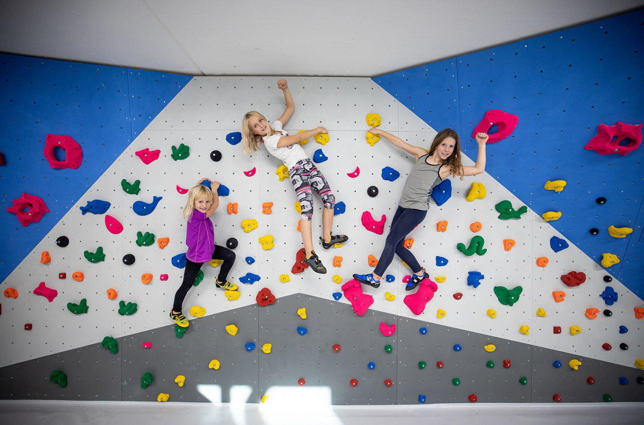 Drei Kinder an einer Wand der Boulderlounge Schlieren.