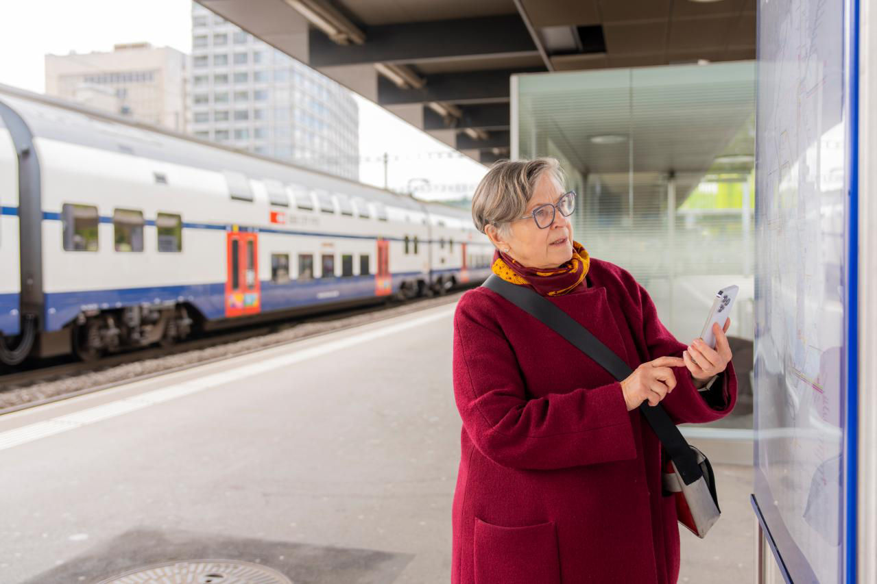 Ein Senior steht am Ticketautomat und kauft ein Billett.