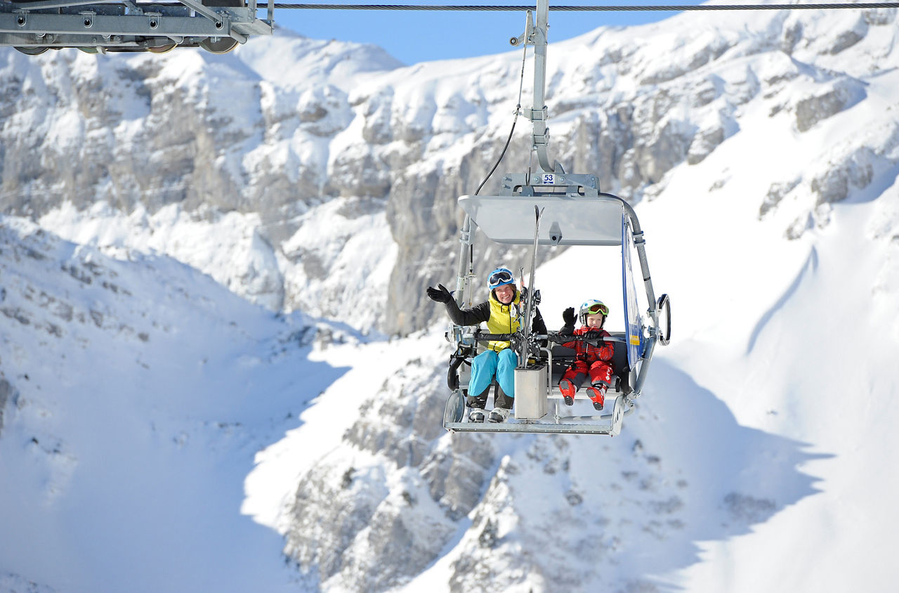 Mutter und Sohn auf einem Sessellift in Braunwald im Winter