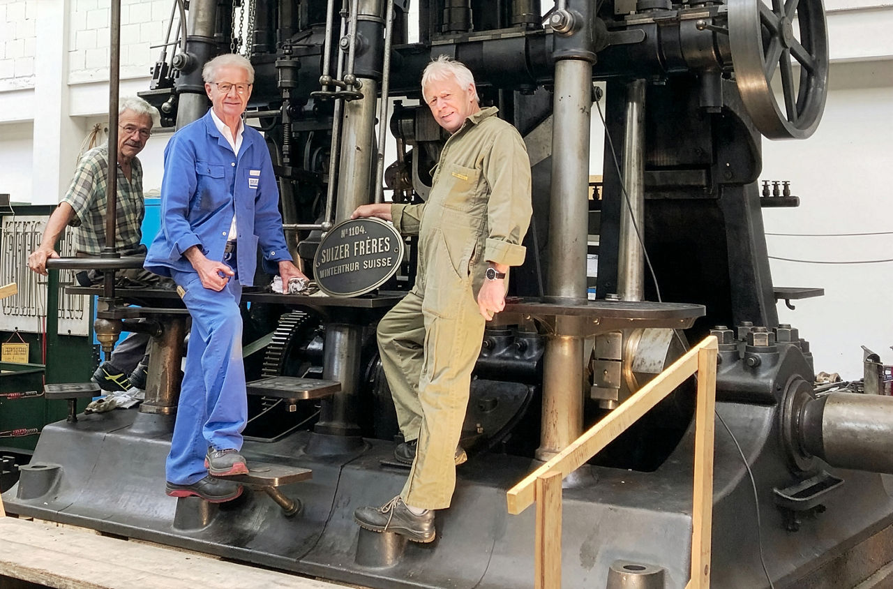 Drei Personen stehen um eine Maschine im Dampfzentrum.