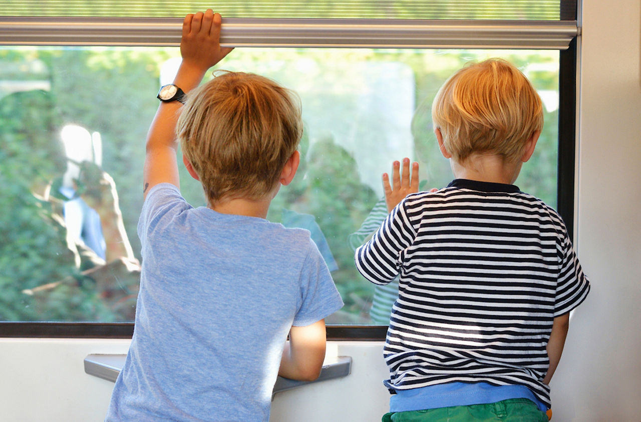 Zwei Buben schauen aus dem Zugfenster.